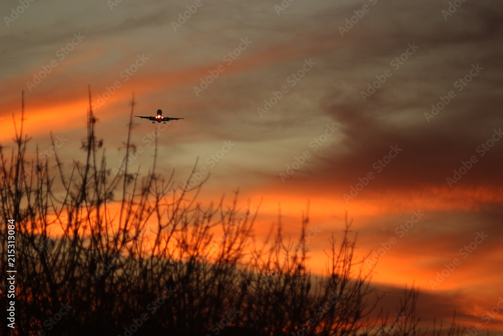 Avión volando sobre el cielo anaranjado de atardecer