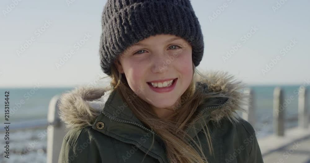 portrait of happy little girl on beach laughing cheerful dressed warm wearing beanie hat and coat portrait of happy little girl on beach laughing cheerful dressed warm wearing beanie hat and coat