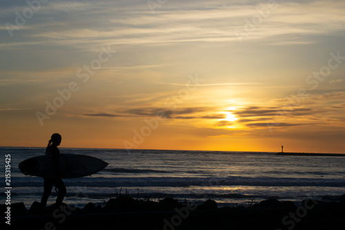 silhouette of a surfer on the beach at sunset