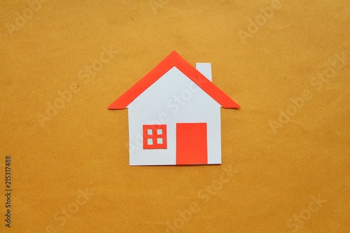 Paper cut of house red roof on brown background,top view. 