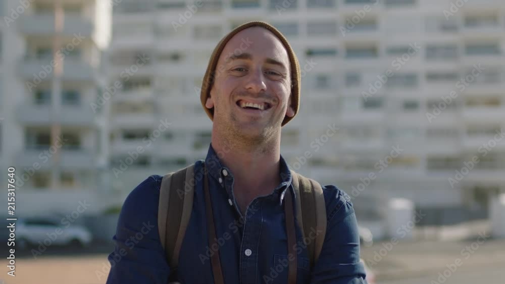portrait of handsome young caucasian man laughing cheerful enjoying successful carefree lifestyle wearing relaxed fashion beanie on warm sunny urban day