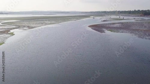 Drone flying over the beautiful beach of Lympstone England. Docked boats can be seen in the distance, as well as hills and mountains. photo