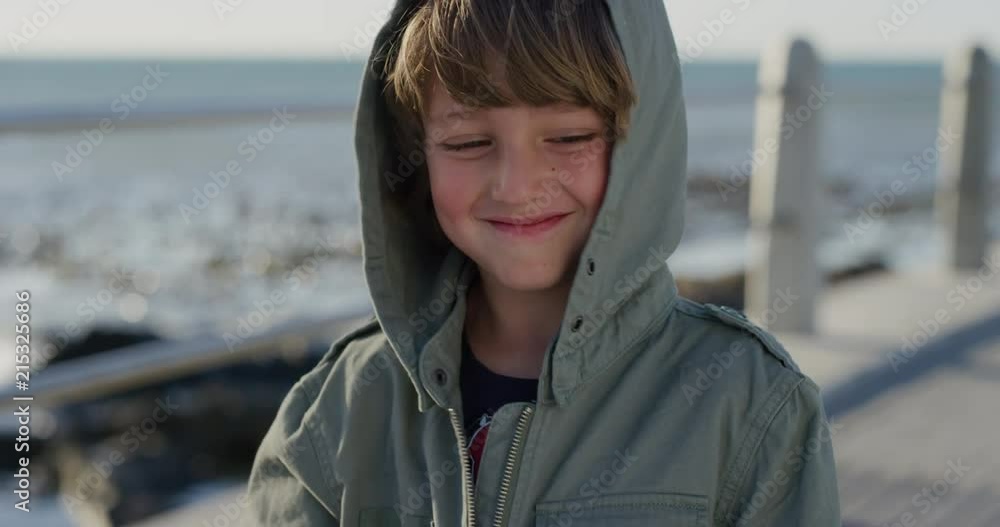 close up portrait playful little caucasian boy smiling happy enjoying ocean seaside wearing jacket on windy sunny day slow motion close up portrait playful little caucasian boy smiling happy enjoying ocean seaside wearing jacket on windy sunny day slow motion