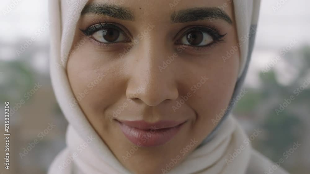 close up portrait of young muslim business woman looking up at camera confident wearing traditional hijab headscarf in office workspace background close up portrait of young muslim business woman looking up at camera confident wearing traditional hijab headscarf in office workspace background