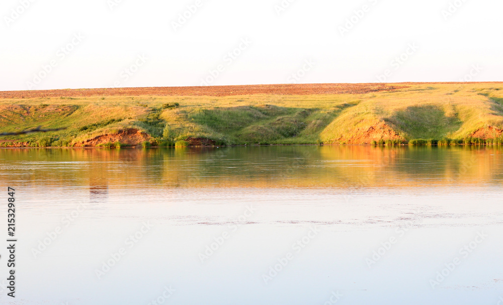 Obraz premium opposite shore of the pond at sunset