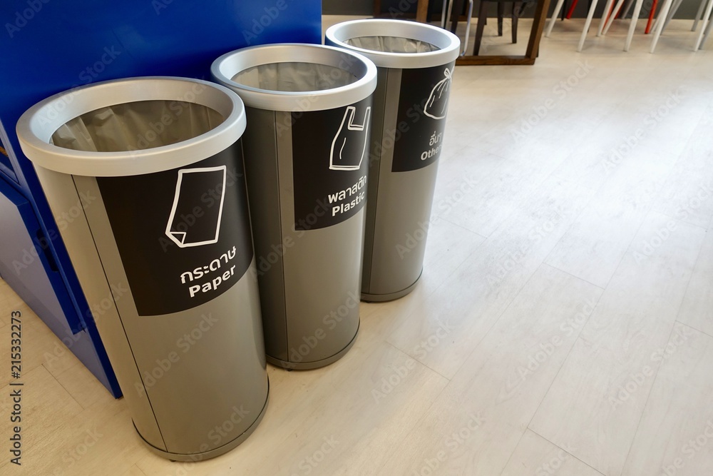 Three grey separate plastic container, which are recycling symbols stamped on paper, plastics, and other materials in front, trash in department store, 3 kinds of recycle bin. Three grey separate plastic container, which are recycling symbols stamped on paper, plastics, and other materials in front, trash in department store, 3 kinds of recycle bin.