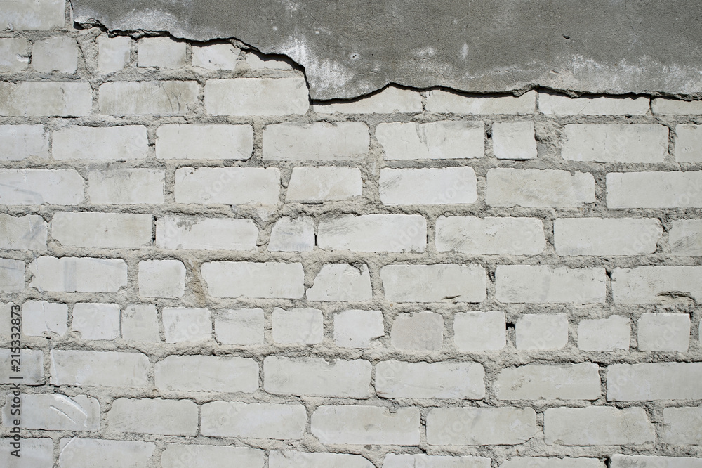 Wall with partially removed plaster in the form of figured drawing of a brick texture. Background Wall with partially removed plaster in the form of figured drawing of a brick texture. Background