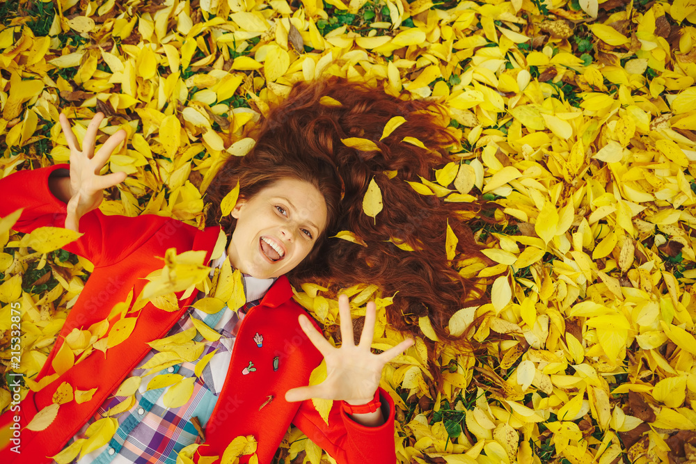 Beautiful happy girl laying in yellow autumn leaves. Beautiful happy girl laying in yellow autumn leaves.