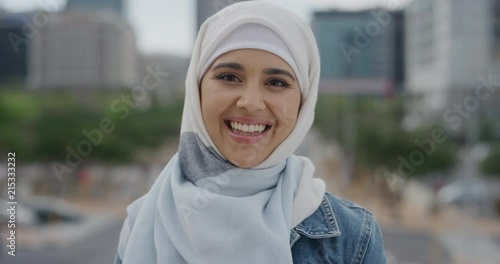 portrait young beautiful muslim woman laughing enjoying successful urban lifestyle independent female student wearing hijab headscarf in city wind blowing