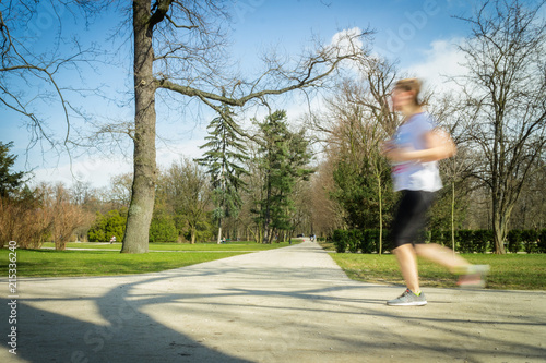 Single woman running alone in park in spring