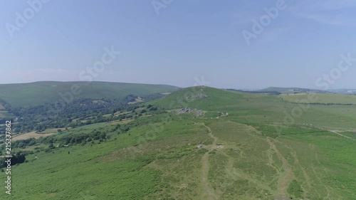 Bonehill Rocks, Wide shot aerial tracking forward over the wide expanse of Dartmoor, tors, grassy moorland and rocky outcrops. Devon, England. photo