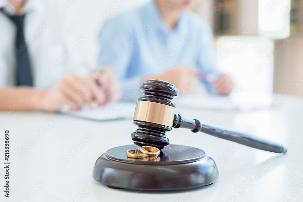 Judge gavel with Justice lawyers deciding, consultation on marriage divorce between married couple and signing divorce documents on table. Concepts of Law and Legal sevices. Judge gavel with Justice lawyers deciding, consultation on marriage divorce between married couple and signing divorce documents on table. Concepts of Law and Legal sevices.