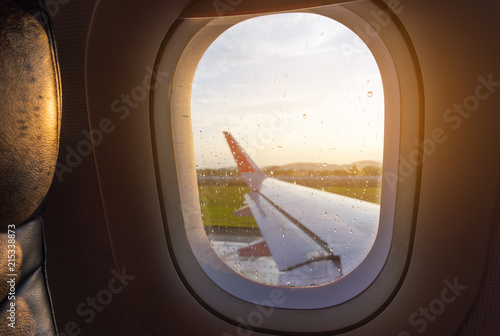 seat and plane window with raindrops.
