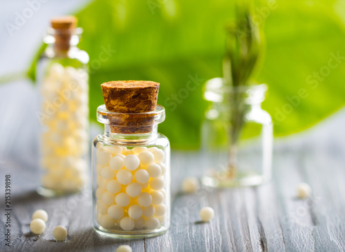 Homeopathy pills bottle wooden eco green leaf background
