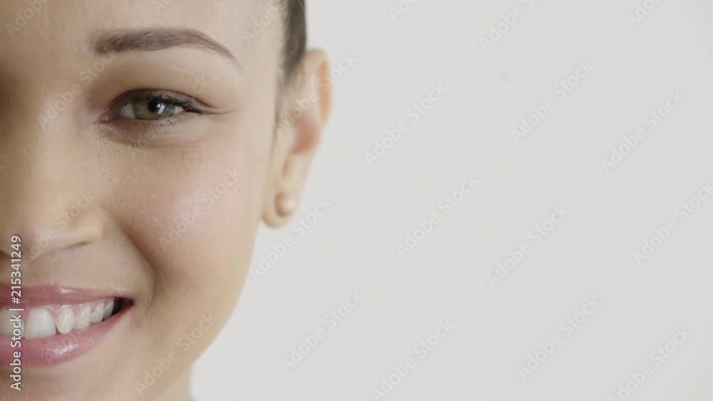 close up beautiful hispanic woman half face smiling happy wearing earings makeup cosmetics on white background close up beautiful hispanic woman half face smiling happy wearing earings makeup cosmetics on white background