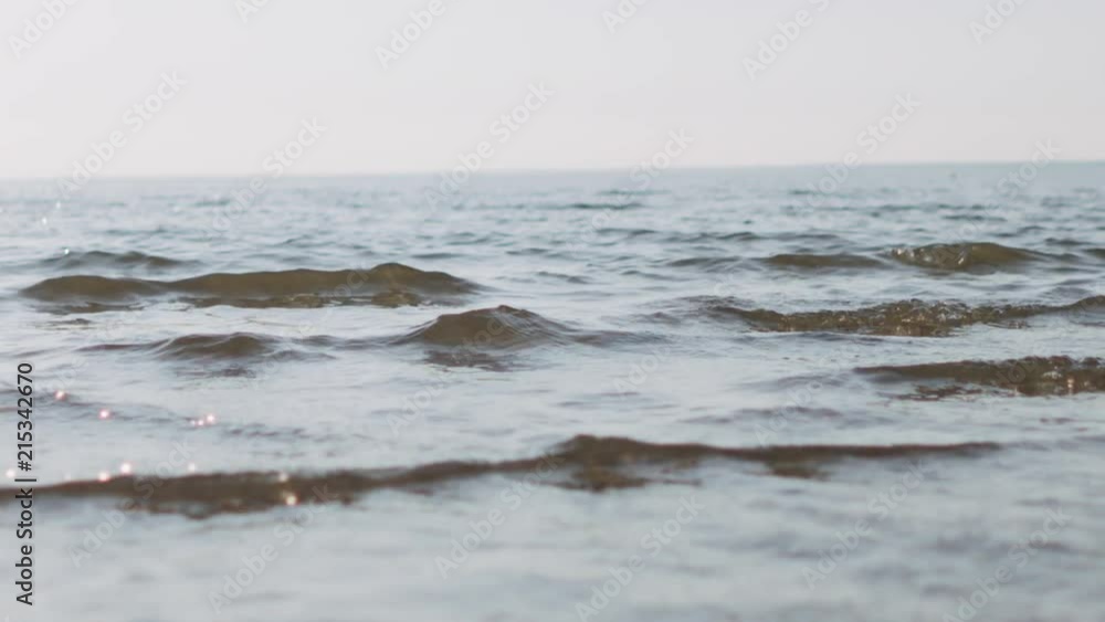 Slow motion handheld closeup of small waves on a beach Slow motion handheld closeup of small waves on a beach