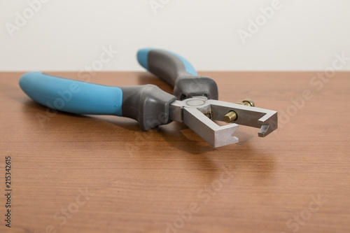 Obraz na plátne Electric tool, blue wire stripper on a wood table