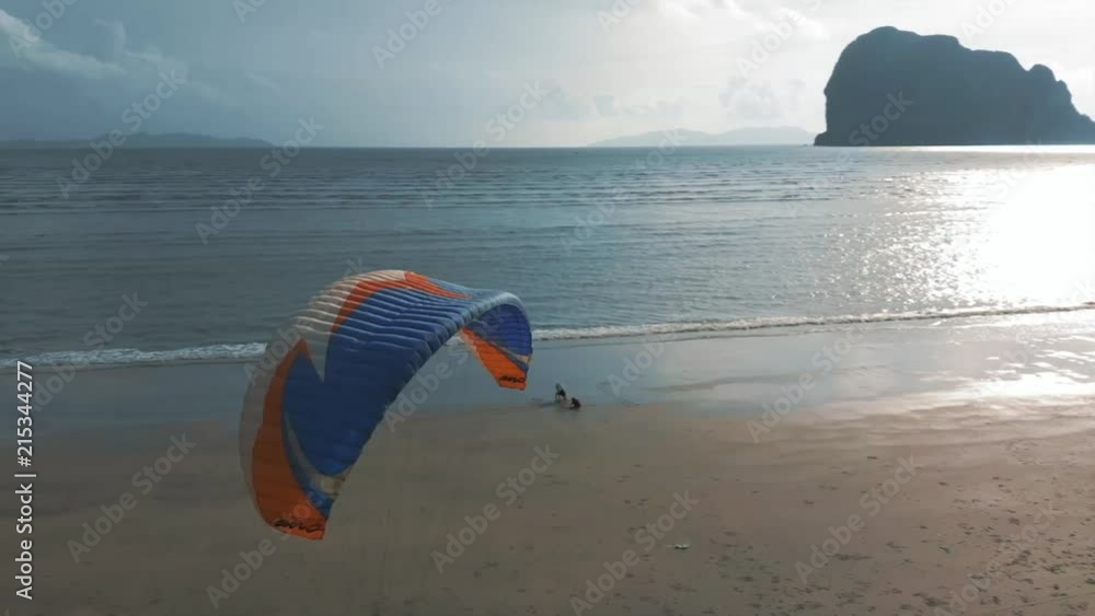 Close-up paramotor flies along the sandy beach. Background with islands view. The coast of Thailand. Trang province. Sikao. Paraglide. Para motor. Cinematic Close-up paramotor flies along the sandy beach. Background with islands view. The coast of Thailand. Trang province. Sikao. Paraglide. Para motor. Cinematic