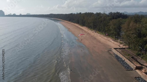 Paramotor flies away along the sandy beach. Background with islands view. The coast of Thailand. Trang province. Sikao. Paraglide. Para motor photo