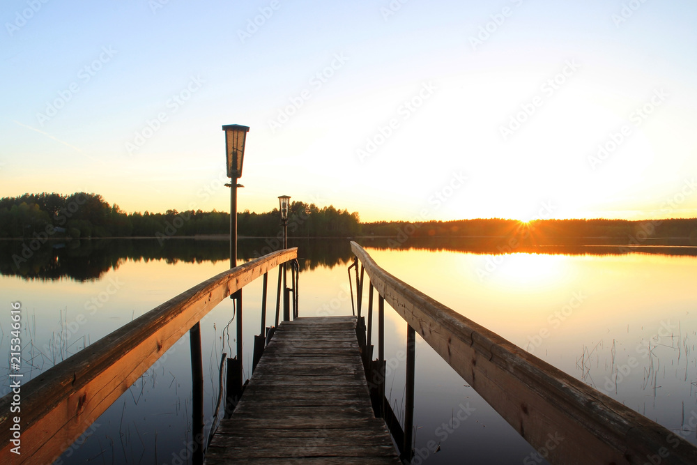 Footbridge on the lake during sunset