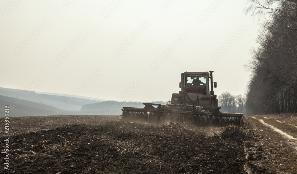 Fototapeta premium Harrowing the soil with disc harrows