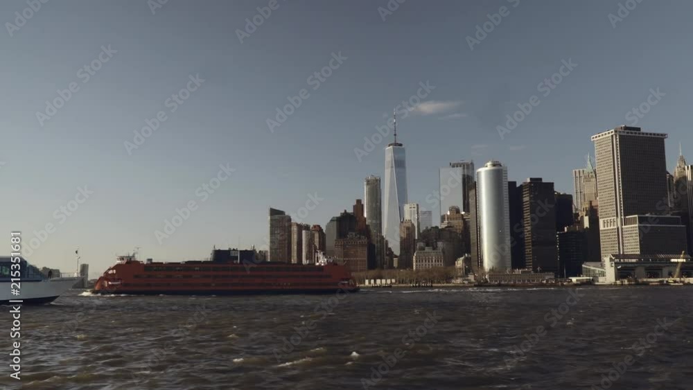 Taxi boat passing by financial skyscrapers in downtown New York in Lower Manhattan filmed from the river in late afternoon Taxi boat passing by financial skyscrapers in downtown New York in Lower Manhattan filmed from the river in late afternoon