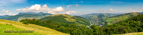panorama of beautiful mountainous rural area. village down in the valley. agricultural fields on hills