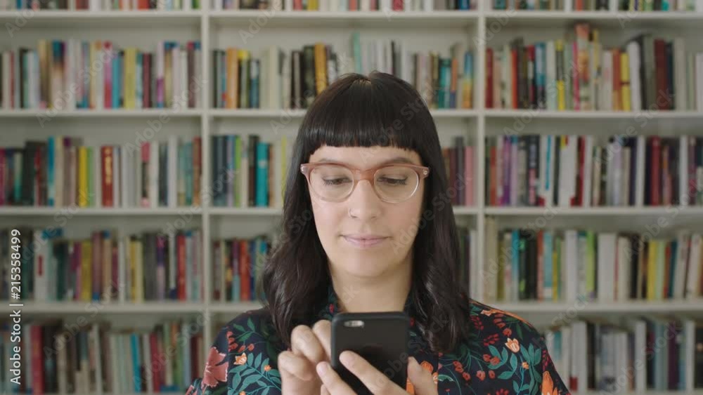portrait young woman student using smartphone bookshelf library university portrait young woman student using smartphone bookshelf library university