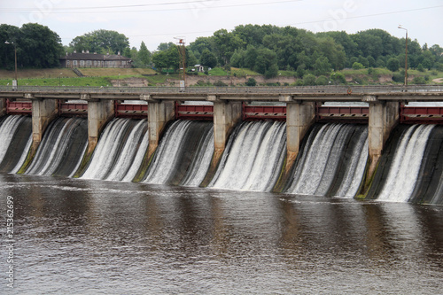 Water falls from a high dam hydroelectric plant into the river