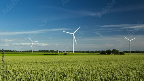 Time lapse of spinning wind turbines for electrical power generation with cloudy sky in Normandy, France. Modern technology of environment friendly energy production