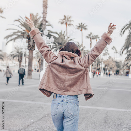 Portrait of happy smiling woman standing on the square on sunny summer or spring day outside  cute smiling woman looking at you  attractive young girl enjoying travel  filtered image  flare sunshine.