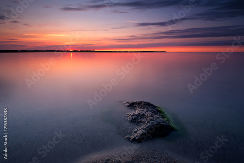 Long exposure of sea with lonely rock. Scenic sunset over the Baltic Sea. Poland