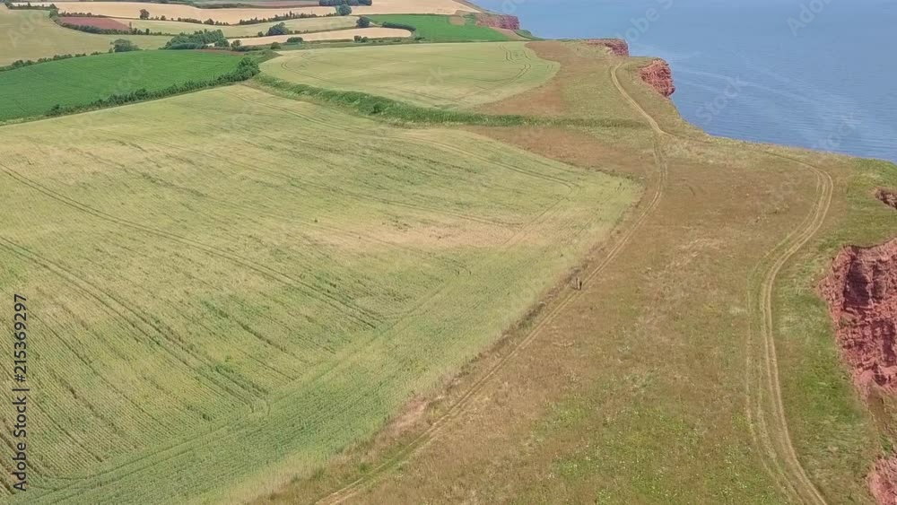 STATIC CROP Aerial, flying over coastal fields at a UK summer beach town STATIC CROP Aerial, flying over coastal fields at a UK summer beach town