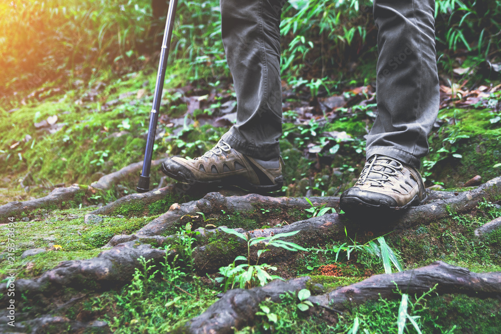 Hiking man with trekking boots on the bright green moss passage trail Hiking man with trekking boots on the bright green moss passage trail