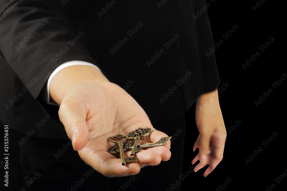 Fototapeta premium Hand holding triple key isolated on black with clipping path.
