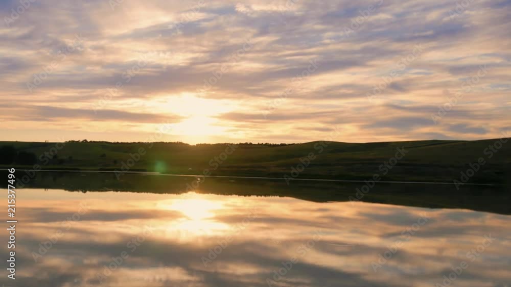 Time lapse of clouds dancing in the wind above a beautiful pond. Sunset footage with moving clouds reflection in a pond. Time lapse of clouds dancing in the wind above a beautiful pond. Sunset footage with moving clouds reflection in a pond.
