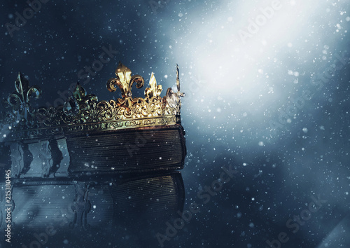 mysteriousand magical image of old crown and book over gothic black background. Medieval period concept.