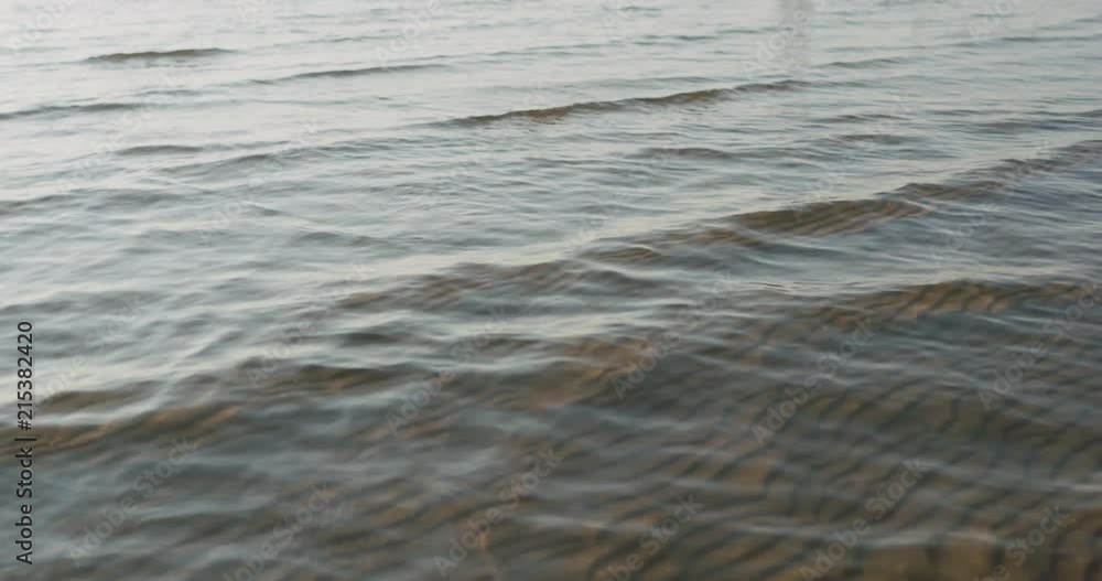 Slow motion pan closeup of small waves on a beach Slow motion pan closeup of small waves on a beach