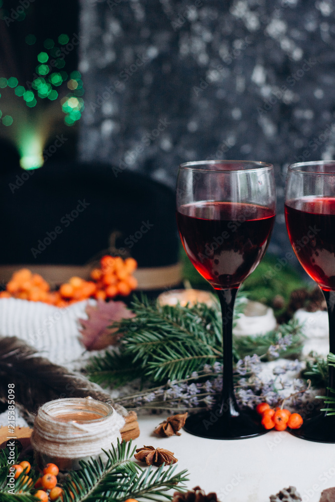 Mulled wine in glasses ,red berries,bumps and autumn branches on wooden table. Autumn or Winter concept.