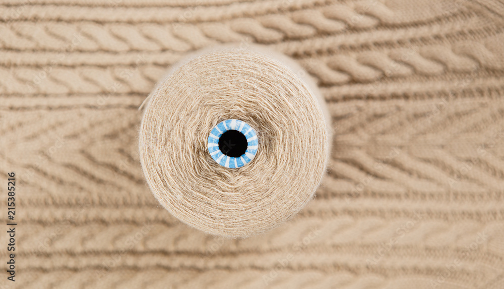 Nude colour skein on the knited textile background Nude colour skein on the knited textile background
