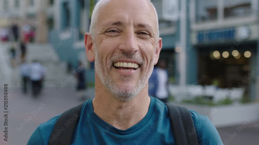 portrait of mature attractive caucasian tourist man looking at camera laughing city background portrait of mature attractive caucasian tourist man looking at camera laughing city background