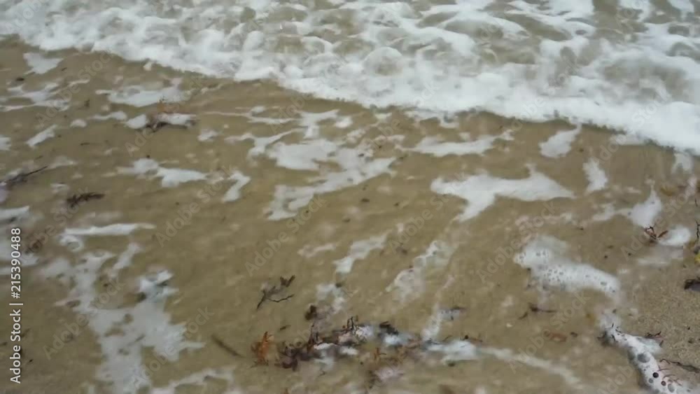 Extreme closeup of wave on Delray Beach in Florida. Two sets of slowly moving waves sweep over a tropical sandy beach. Extreme closeup of wave on Delray Beach in Florida. Two sets of slowly moving waves sweep over a tropical sandy beach.