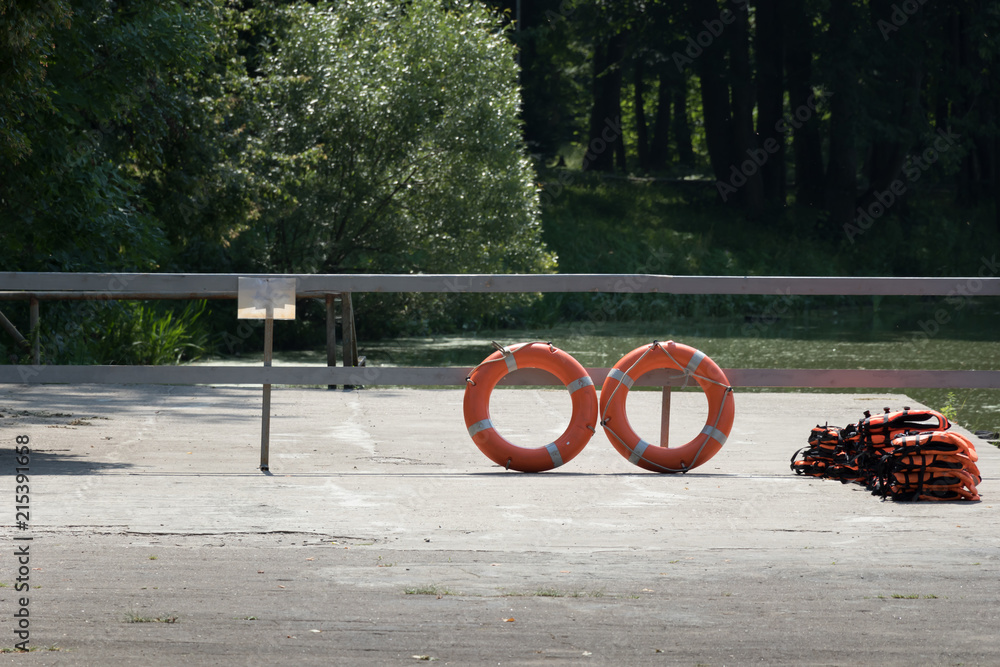 Obraz premium pier with lifebuoy and life jackets