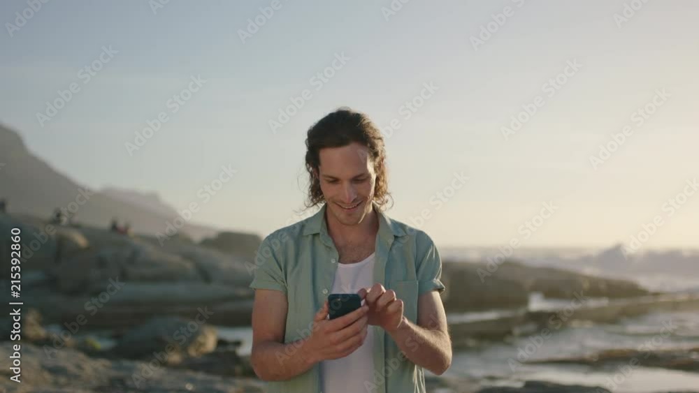 portrait of man using phone texting by beach at sunset portrait of man using phone texting by beach at sunset