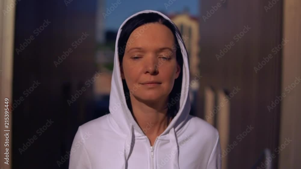 portrait attractive caucasian jogger. brunette wearing hood trains outdoor. close up face adult woman running in the morning portrait attractive caucasian jogger. brunette wearing hood trains outdoor. close up face adult woman running in the morning