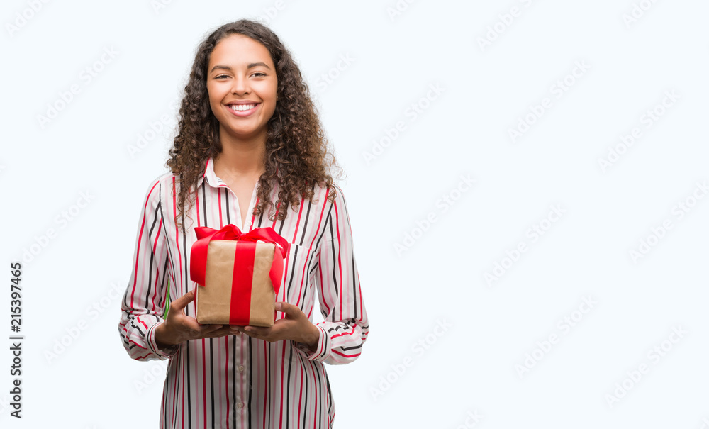 Young hispanic woman in love holding present with a happy face standing and smiling with a confident smile showing teeth Young hispanic woman in love holding present with a happy face standing and smiling with a confident smile showing teeth