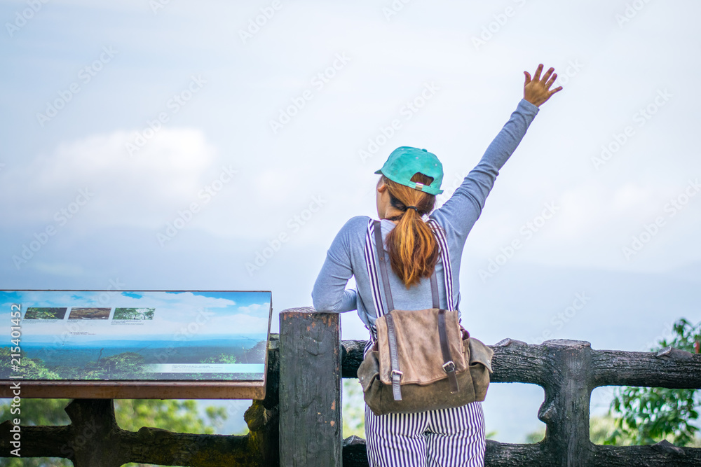 Asian female traveller carrying backpack on the top of mountain looking down to the bottom Asian female traveller carrying backpack on the top of mountain looking down to the bottom