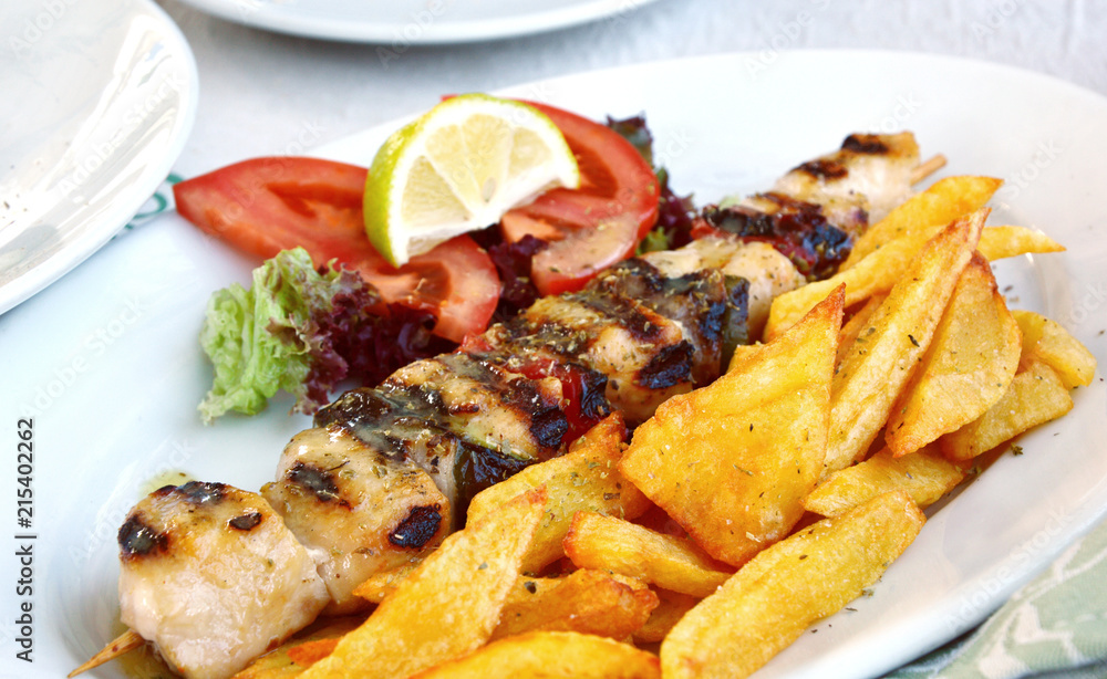 Grilled Greek Chicken with Tzatziki Sauce with French fries and lime. 