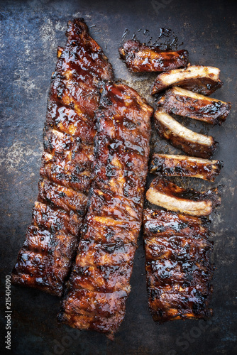 Barbecue spare ribs St Louis cut with hot honey chili marinade as top view on a rusty board