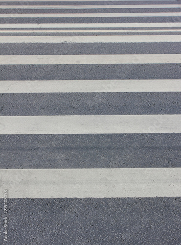 Pedestrian Crosswalk with Parallel Painted White Lines on Gray Asphalt Background. Close Up View of Empty Pedestrian Crossing Point at Downtown City Street with No People.